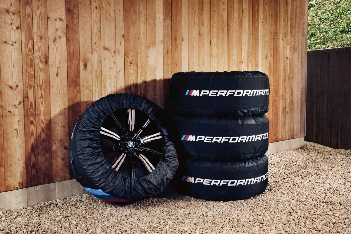 Ein Stapel von vier BMW M-Performance Sommerreifen steht an der Wand eines Carports.