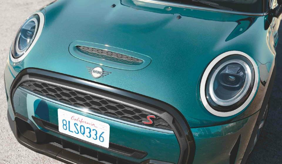 Die in grün metallic glänzend lackierte Motorhaube eines MINI Cabrio S.