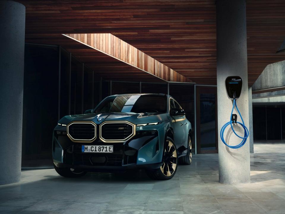 Ein BMW XM steht in einer Tiefgarage. Neben dem Fahrzeug hängt eine original BMW Wallbox an einer Säule.