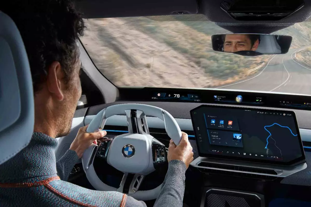 Ein Mann f&auml;hrt mit einem BMW iX3 auf einer freien Landstra&szlig;e.