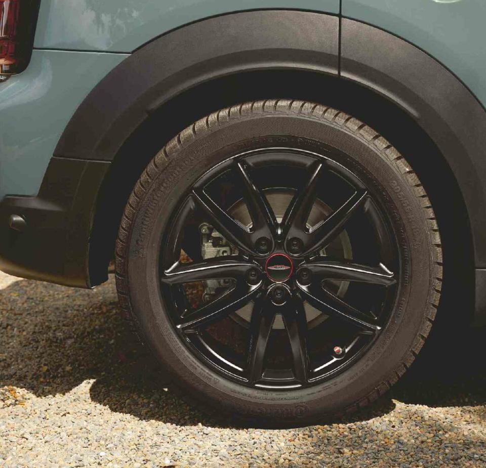 Der rechte Hinterreifen eines MINI Countryman in "smokey green" mit schwarzen Alufelgen im 10-Speichen Design.