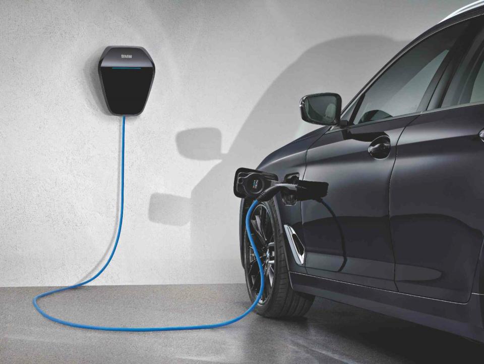Ein BMW i4 parkt in einer Garage neben einer Wallbox und wird aufgelagen.