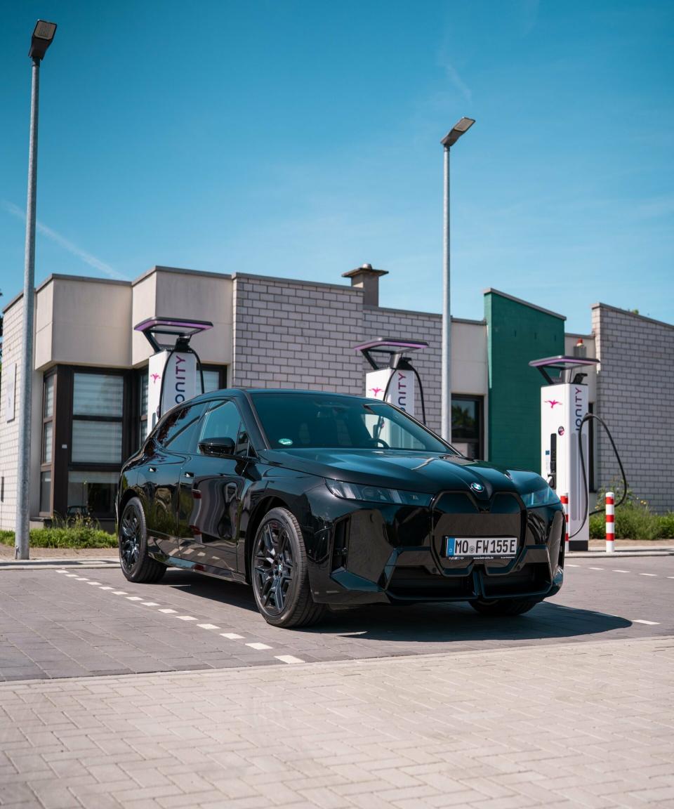 BMW iX xDrive45 von Fett und Wirtz steht vor Ladesäule am Ionity Ladepark in Kamp-Lintfort