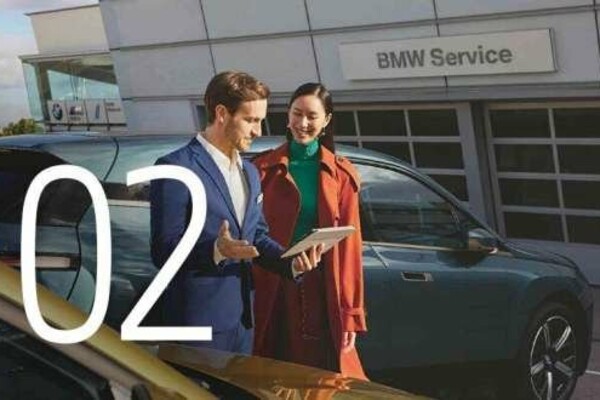 Nummer 2: BMW Servide-Mitarbeiter erklärt einer Dame etwas an ihrem dunkelgrünen BMW auf seinem Tablet.