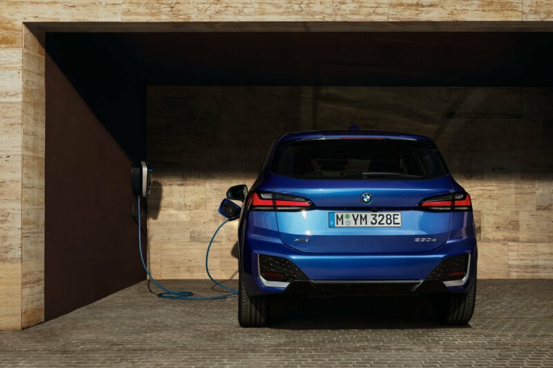 Ein BMW 230e xDrive Active Tourer beim Aufladen in einem Carport.