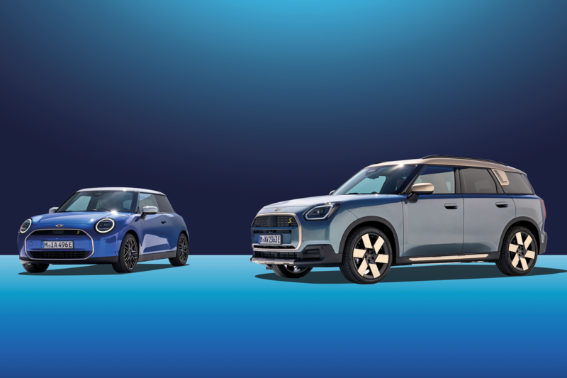 Ein MINI Cooper E und MINI Countryman E parken schräg zueinander in einer blauen Fotokulisse.