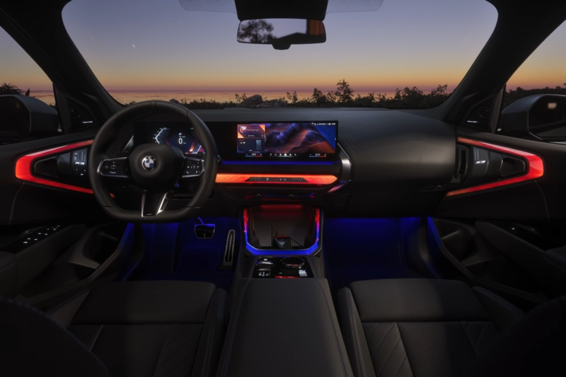 Der vordere Innenraum eines BMW X3 mit roter Ambientebeleuchtung.
