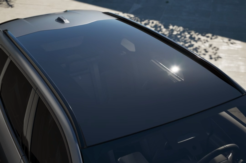 Das abgedunkelte Panoramadach eines BMW X3 an einem sonnigen Tag.