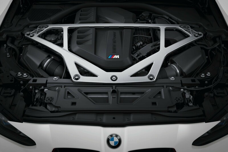 Der Motor eines weißen BMW M3 Competition mit Stabilisatoren.