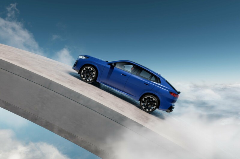 Ein BMW X2 M35i xDrive fährt auf einer schiefen Ebene auf einem modernen Beton-Kunstwerk.