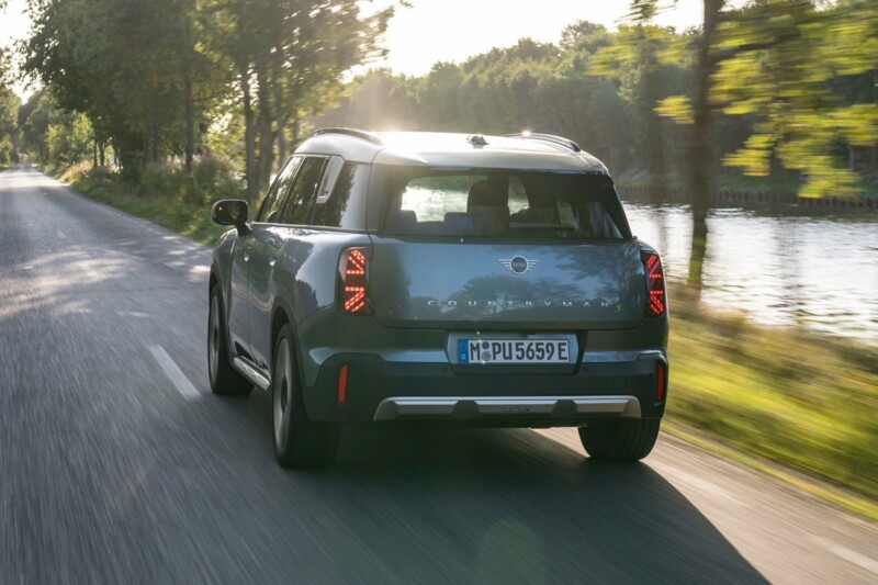 Ein MINI Cooper Countryman fährt auf einer Landstraße neben einem Fluss.