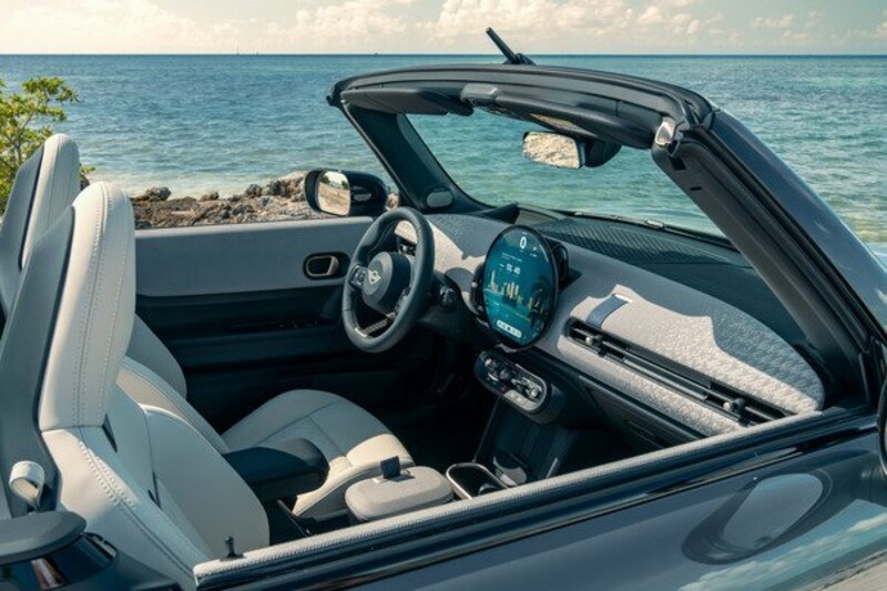 Die vorderen Sitze und das Cockpit eines MINI Cooper Cabrios, welches in der nähe des Meeres parkt.