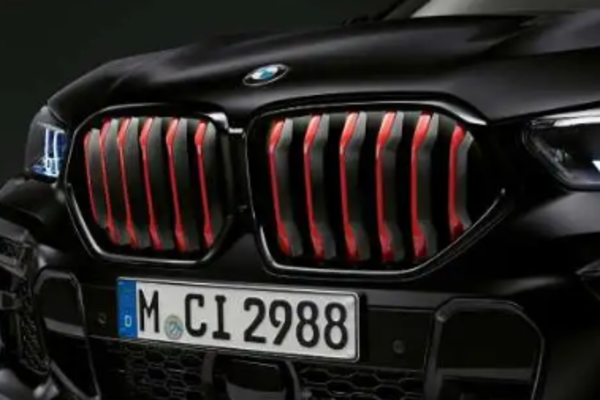 Die BMW Doppelniere mit Stäben in Chili Red eines Frozen Black farbenen BMW X6 xDrive40i M Sport.