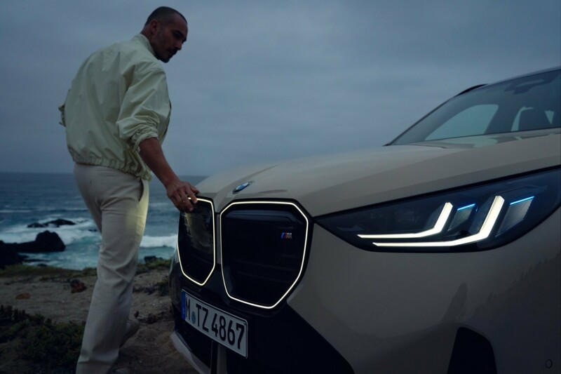 Ein BMW X3 M50 xDrive mit beleuchteter Iconic Glow Niere im Dunkeln.