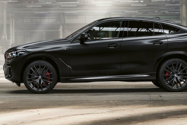 Ein BMW X6 in der Farbe Frozen Black metallic in einer Industriehalle.
