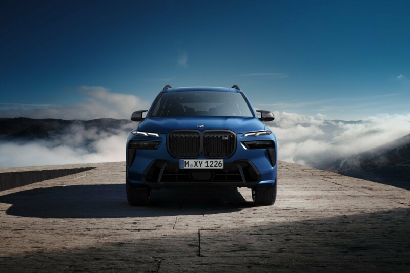 Ein BMW X7 M60i M Performance parkt auf einer schmalen Beton-Brücke.
