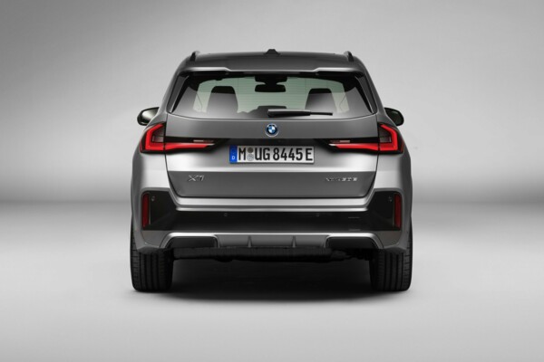 Ein BMW iX1 eDrive30 in der Farbe Frozen Pure Grey metallic in einer Fotokulisse.