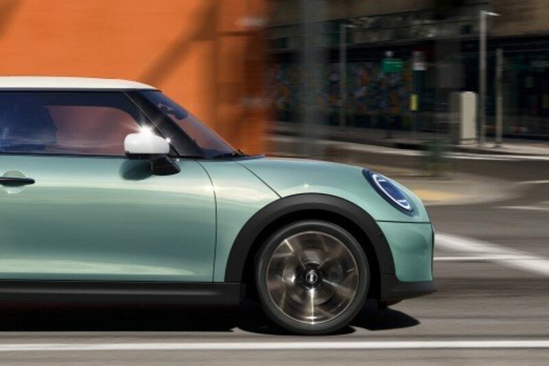 Ein MINI Cooper 3-Türer in der Farbe Ocean Wave Green fährt durch die Innenstadt.