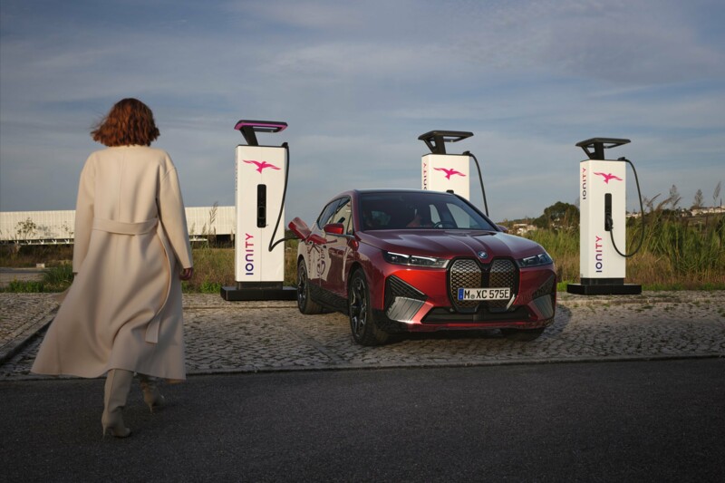 Frau laeuft auf BMW iX an Ionity Ladestation zu