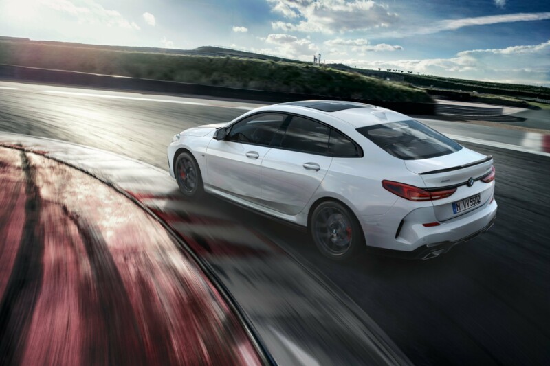 Ein weißer BMW M235i xDrive M Performance fährt auf der Landstraße an einem sonnigen Tag.