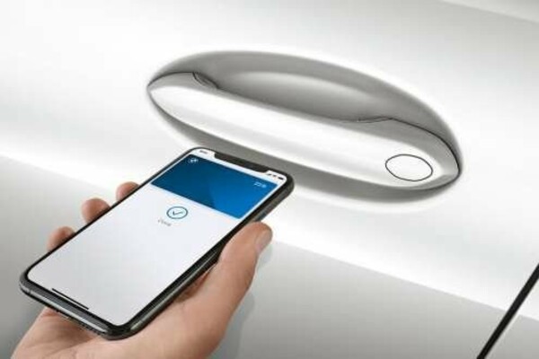Ein Smartphone mit einem BMW Digital Key öffnet einen BMW M8.