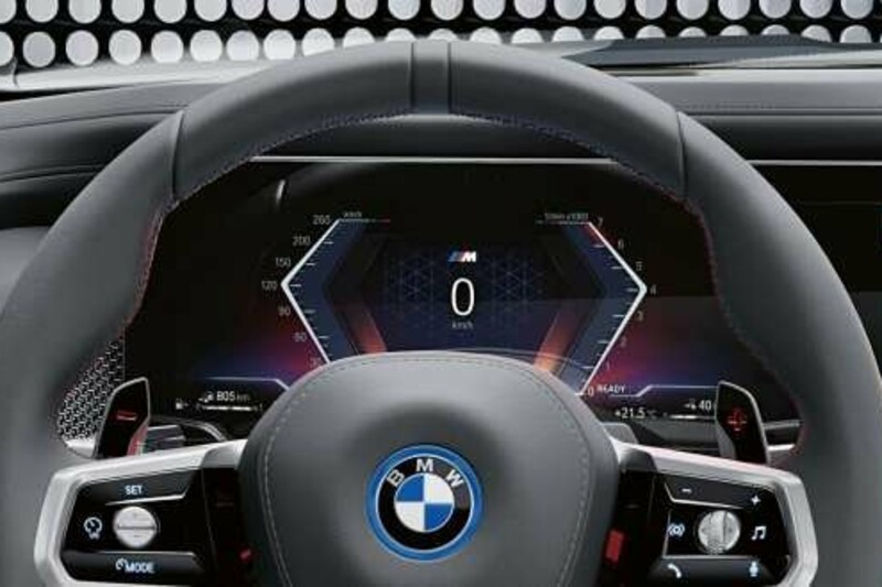 Das Lederlenkrad eines BMW i7 M70 xDrive mit digitalem Kombiinstrument.