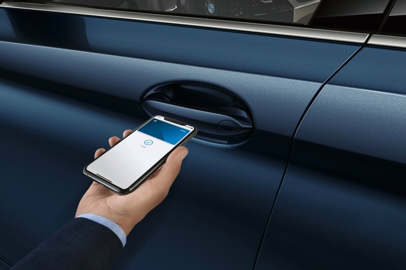 Eine BMW 530e Limousine wird mit Digitalem Key durch ein Smartphone geöffnet.