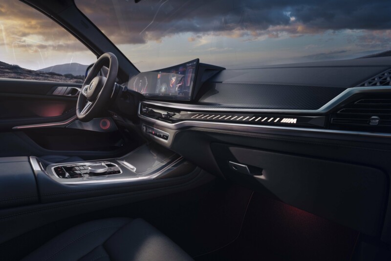 Das Cockpit eines BMW X7 M60i M Performance mit orangefarbener Ambientbeleuchtung und Curved Display.