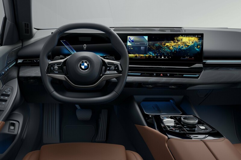 Das Cockpit eines BMW 520d Touring mit Curved Display und Kupferbraunen Ledersitzen.