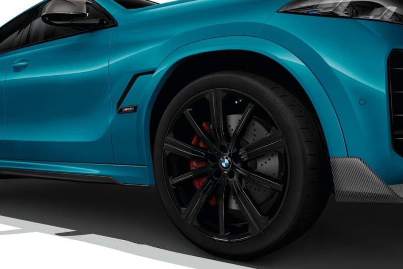 Air Breather mit M60i Badge eines BMW X6 M Competition mit schwarzen Alufelgen im 10-Speichen Design.