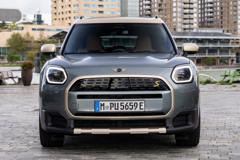 Ein MINI Countryman Electric parkt auf einem öffentlichen Platz inmitten von ein paar Bürogebäuden.