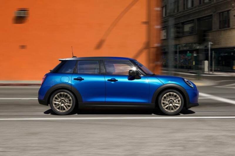 Ein MINI Cooper 5-Türer in der Farbe Blazing blue fährt durch die Innenstadt.