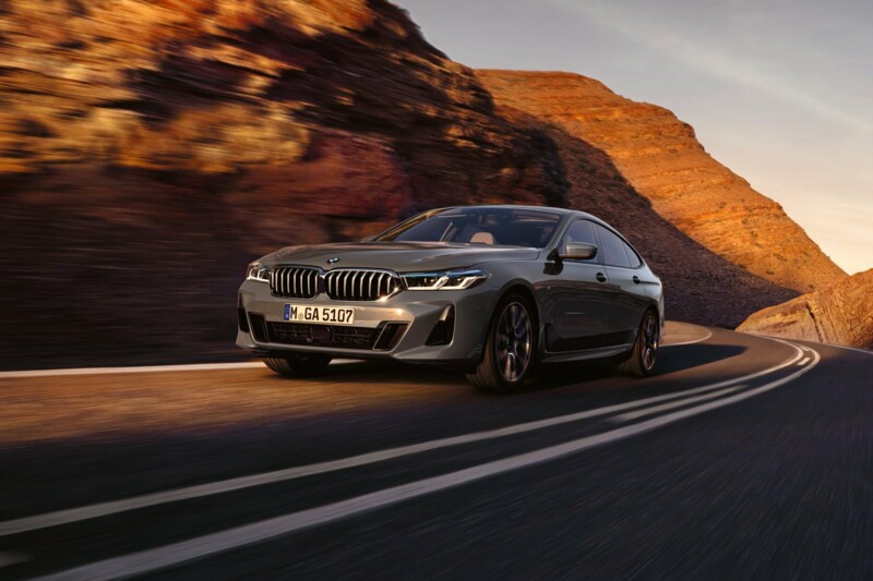 Ein BMW 640i Gran Turismo auf der Landstraße einer Bergregion bei Sonnenuntergang.
