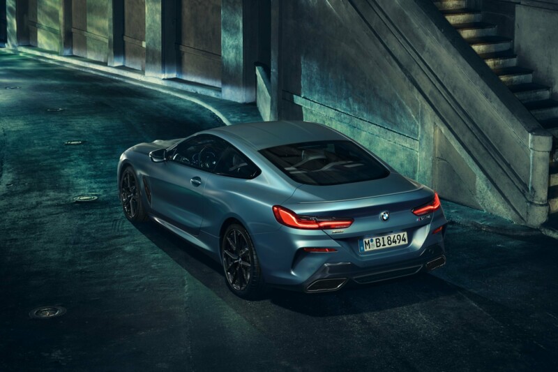Die Heckansicht des M850i xDrive Coupé während einer Fahrt in der Innenstadt bei Nacht.