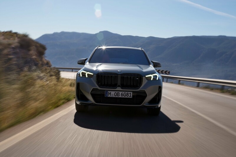 Ein BMW X1 M35i xDrive auf einer rasanten Fahrt auf der Landstraße in den Bergen.